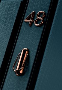 Black door with copper numbers and knocker