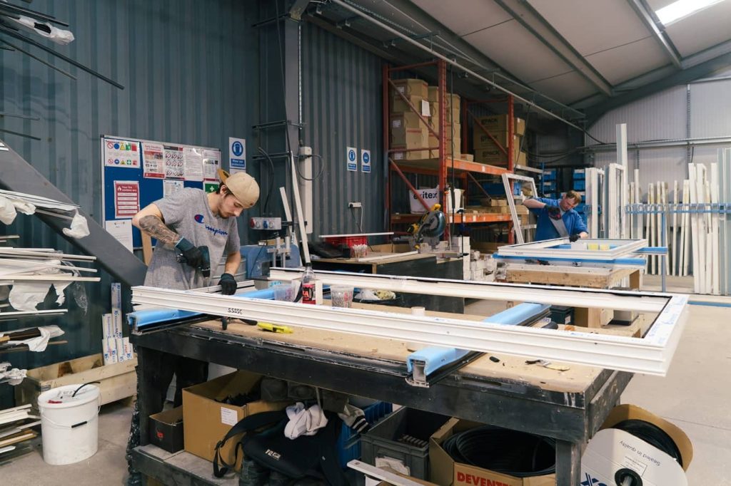 Young male apprentice working in a door factory